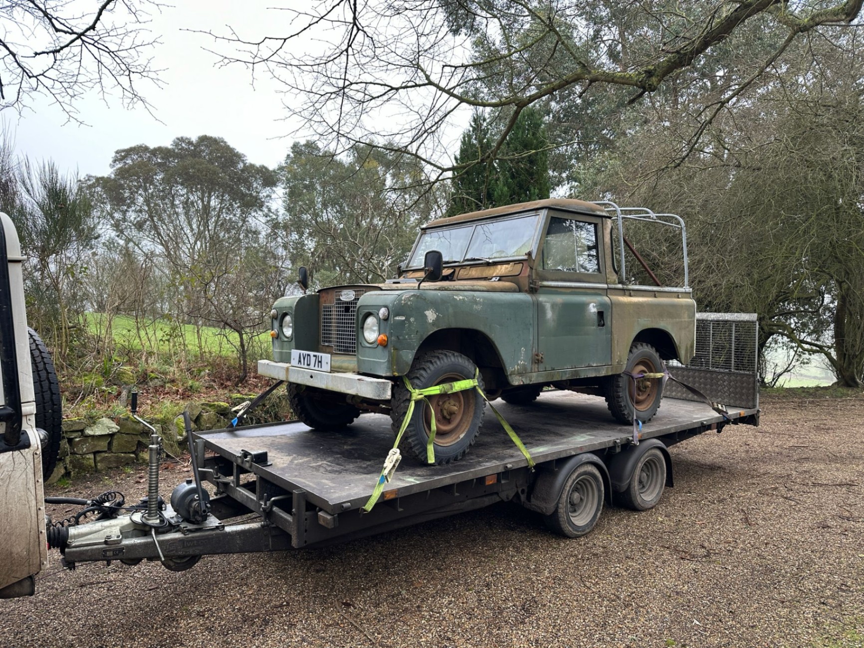 Series Land Rover loaded on a trailer for collection